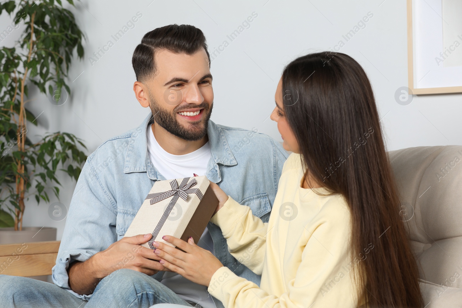 Photo of Lovely couple with beautiful gift at home