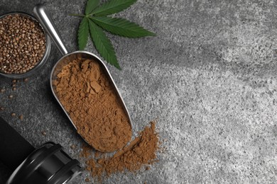 Photo of Hemp protein powder, fresh leaf, seeds and dumbbell on grey table, flat lay. Space for text