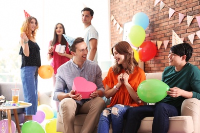 Young people having birthday party in decorated room