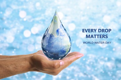 Image of World Water Day. Man holding icon of drop with Earth image inside on blurred background, closeup