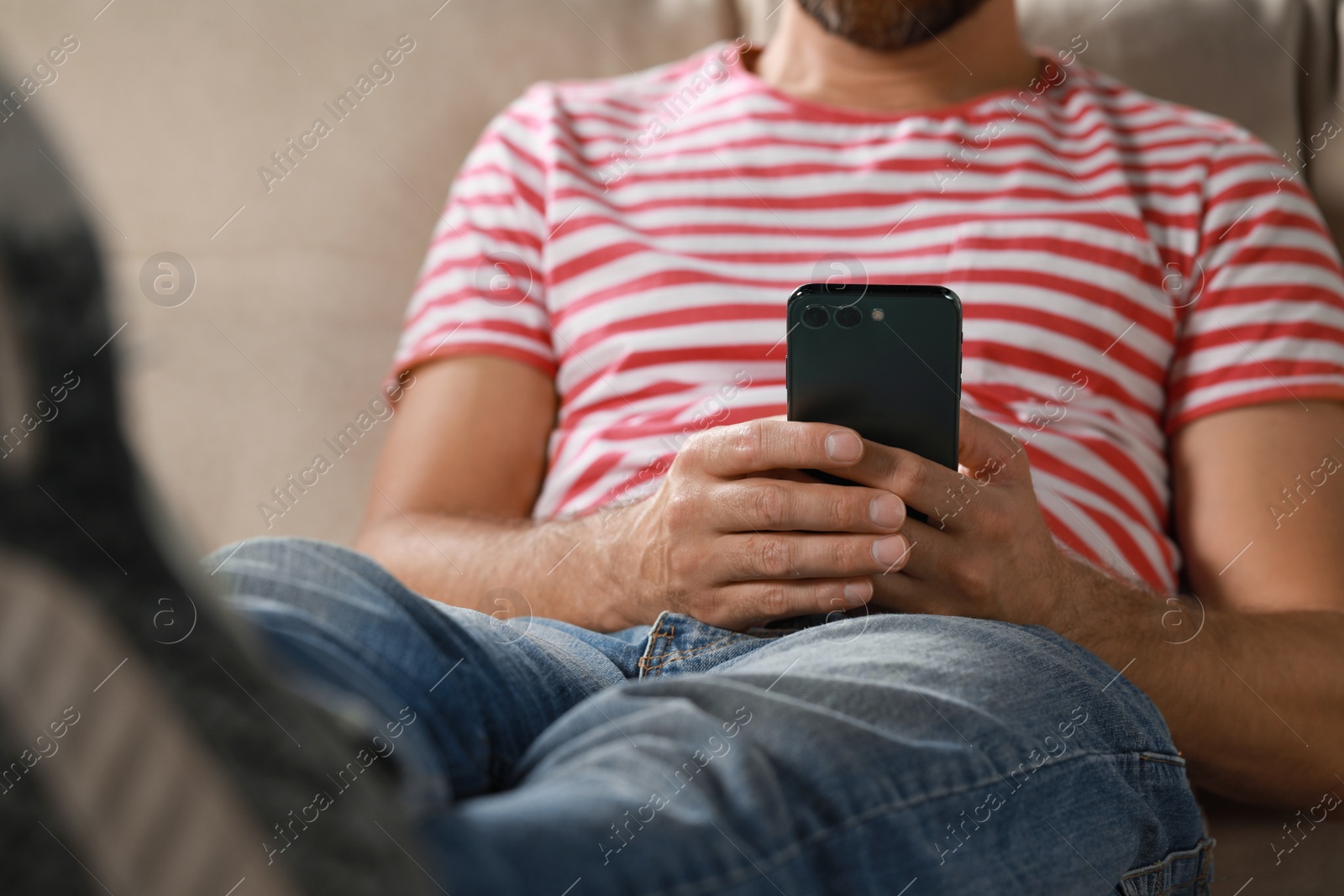 Photo of Man using smartphone at home, closeup view