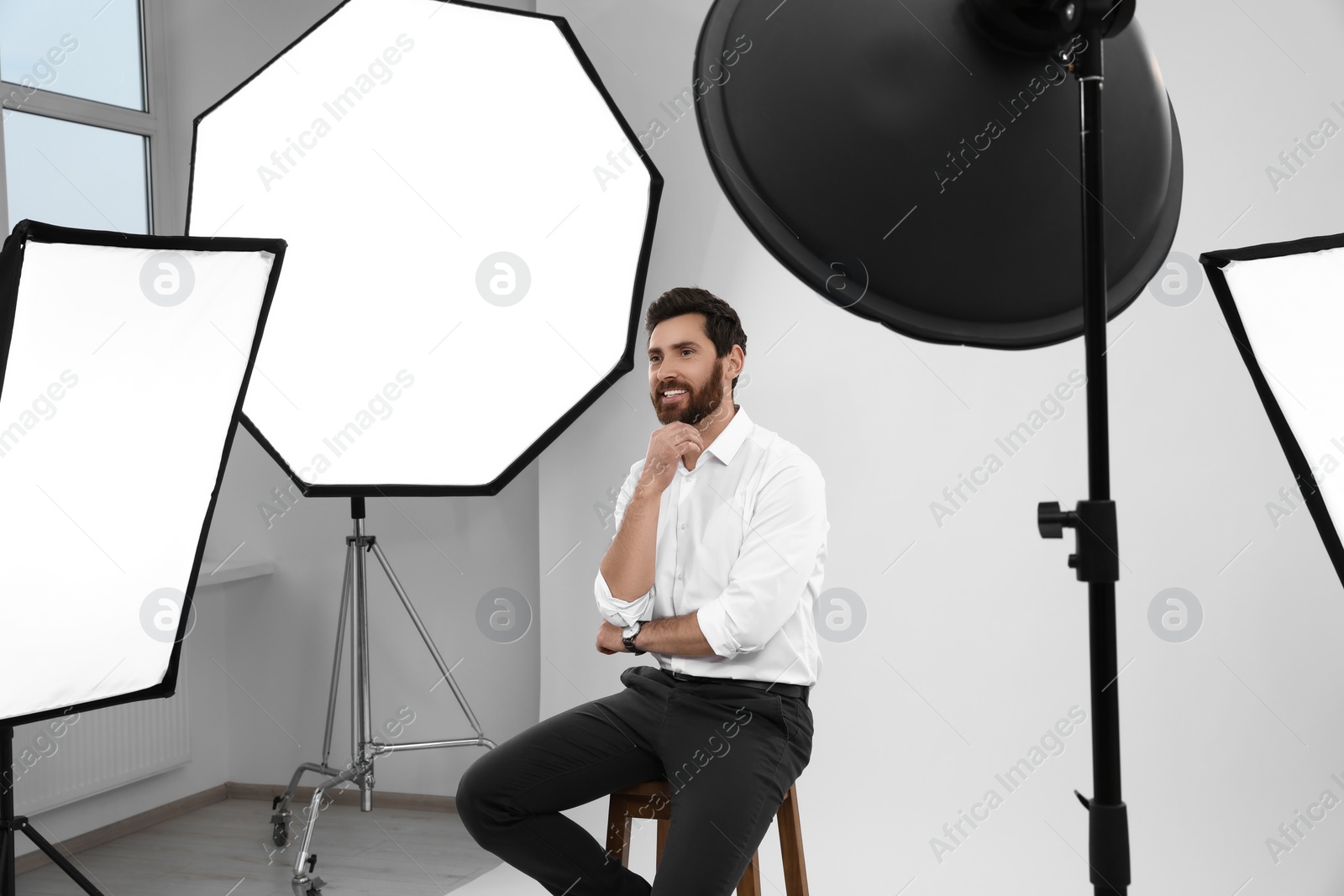 Photo of Handsome model posing in modern studio. Professional photo session