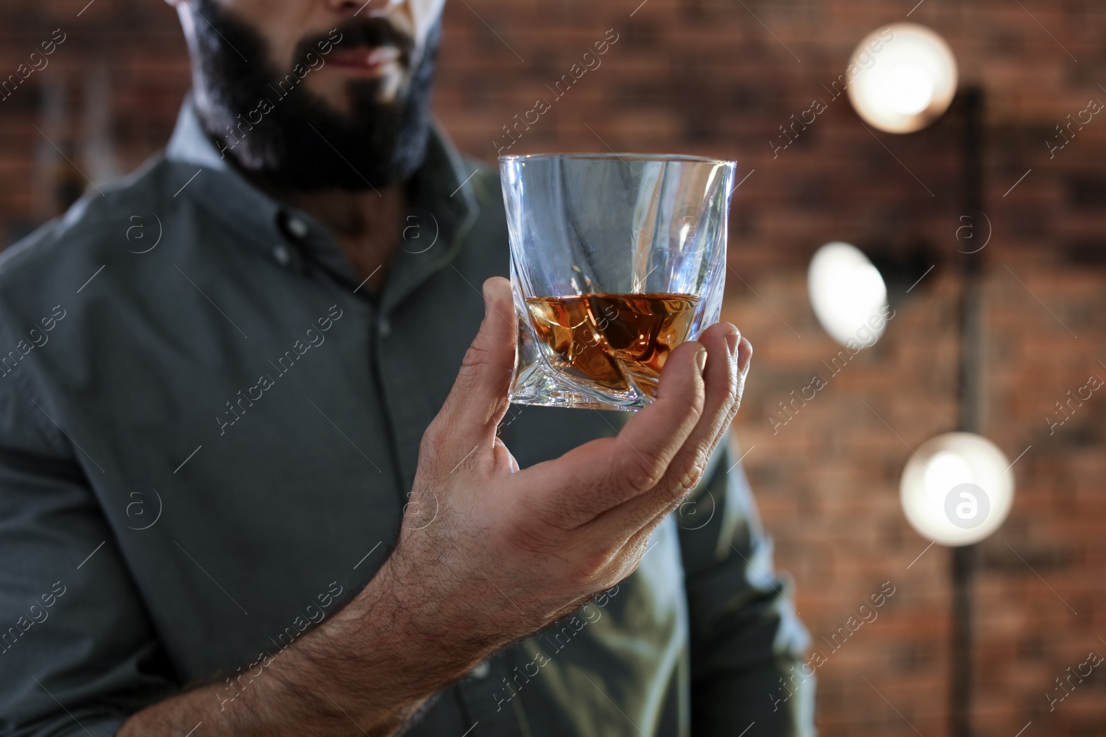 Photo of Man with glass of whiskey indoors, closeup