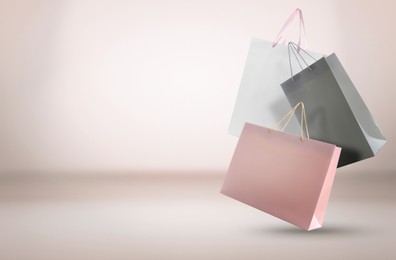 Image of Hot sale. Colorful shopping bags in air on light gradient background, space for text