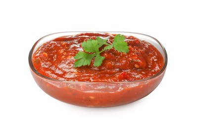 Delicious adjika sauce and parsley in glass bowl isolated on white