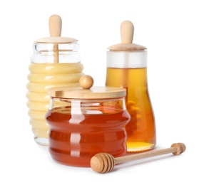 Glass jars with different types of sweet honey on white background