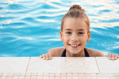 Happy little girl in swimming pool on sunny day