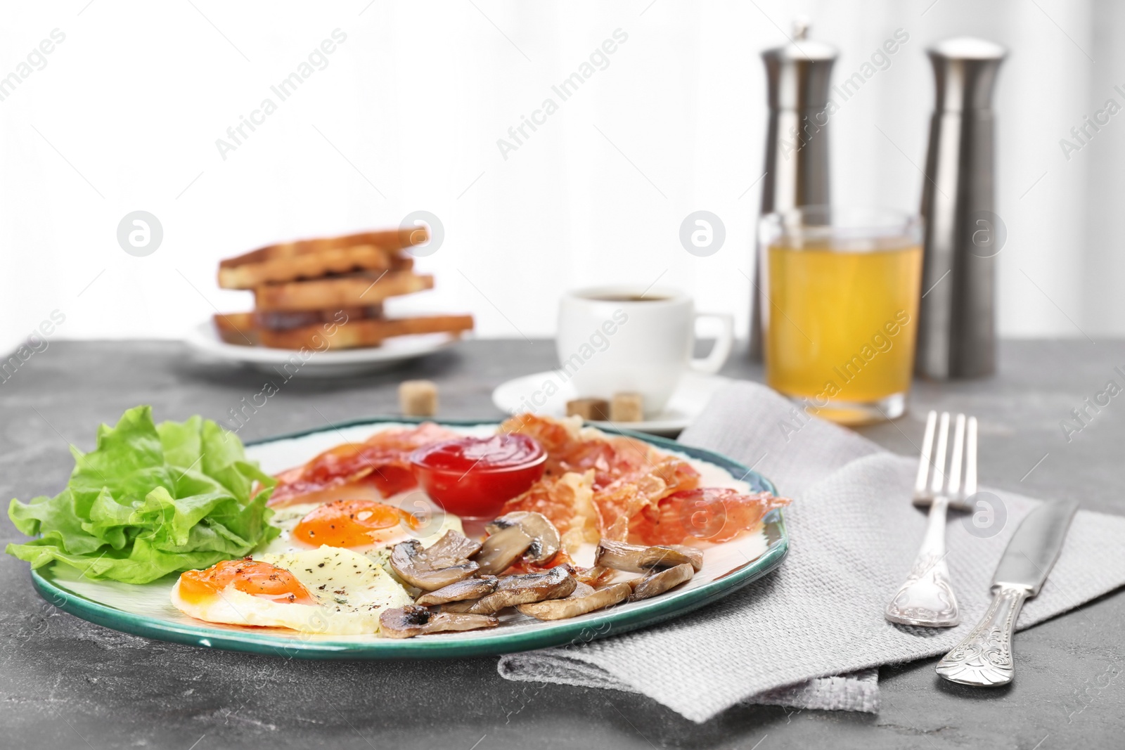 Photo of Plate with fried eggs, bacon and sauce on grey background