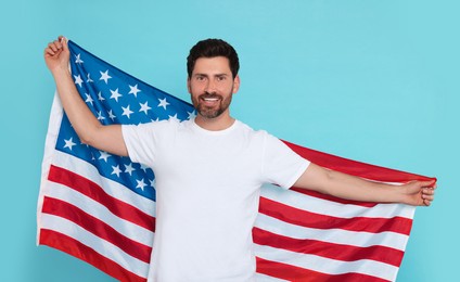 4th of July - Independence Day of USA. Happy man with American flag on light blue background