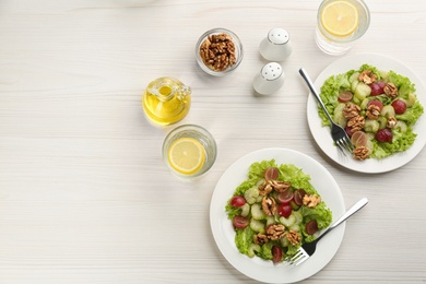 Photo of Delicious fresh celery salads served on white wooden table, flat lay. Space for text