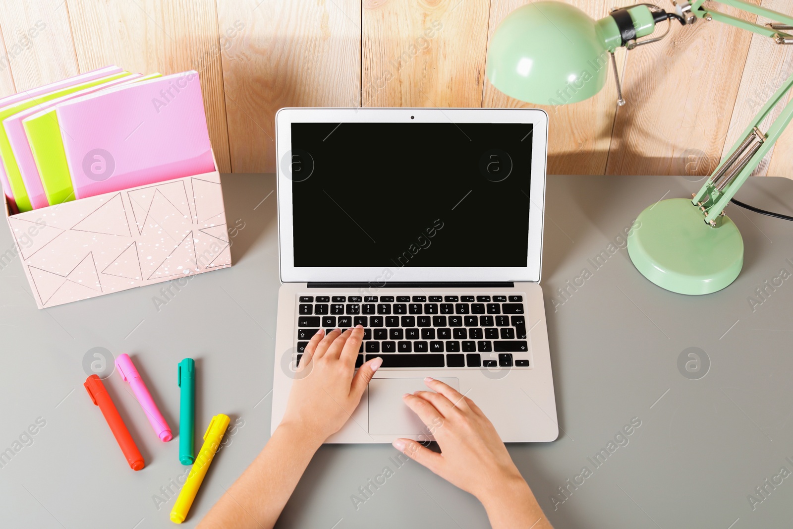 Photo of Woman using laptop with blank screen at table indoors, closeup. Mock up for design