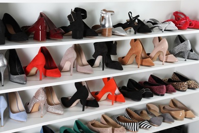 Photo of Shelving unit with different shoes. Element of dressing room interior