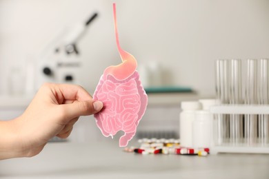 Photo of Woman holding paper intestine cutout in clinic, closeup. Space for text
