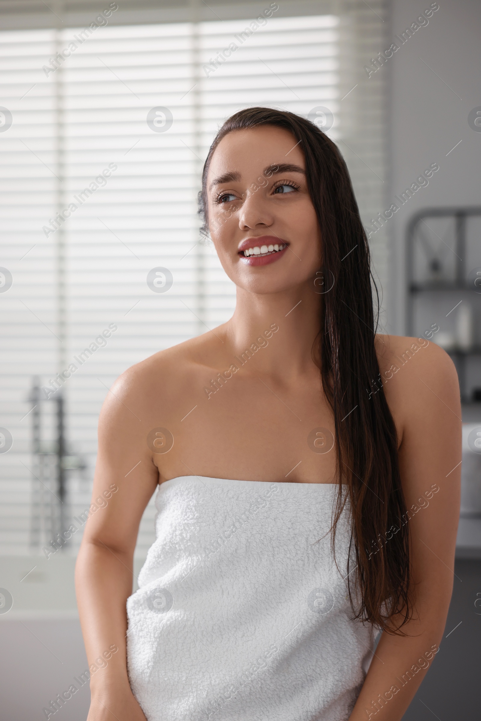 Photo of Smiling young woman after shower in bathroom