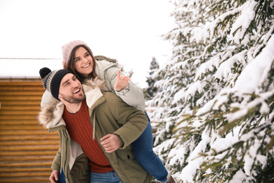 Happy couple spending time together on snowy day. Winter vacation