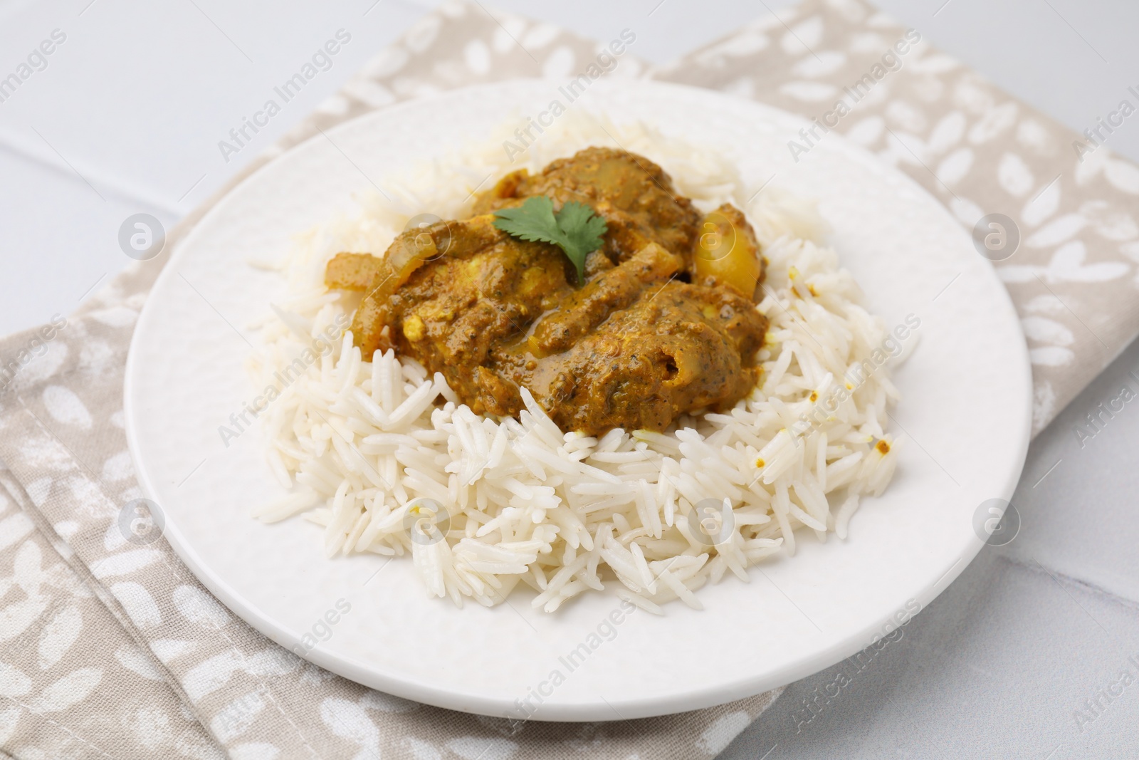 Photo of Delicious chicken curry with rice on white tiled table, closeup