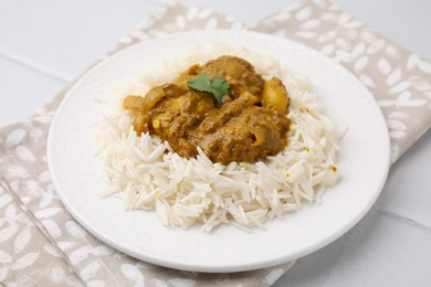 Photo of Delicious chicken curry with rice on white tiled table, closeup