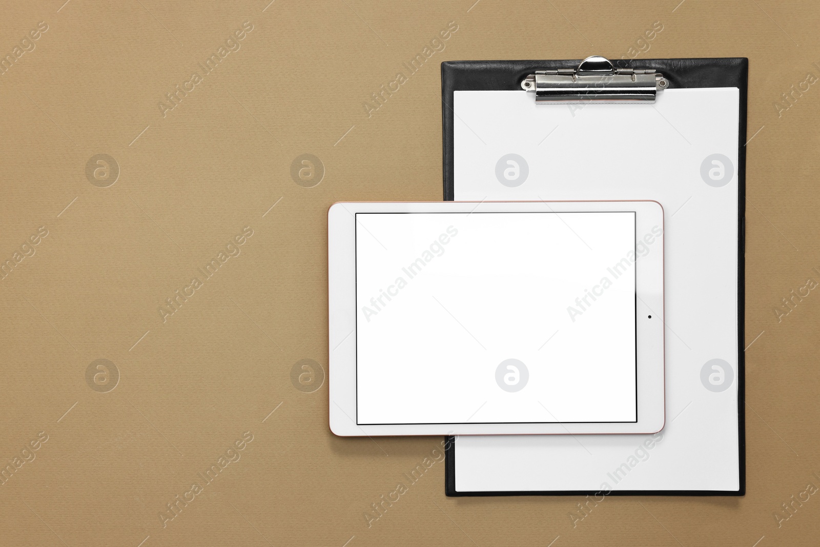 Photo of Modern tablet and clipboard on dark beige background, flat lay. Space for text