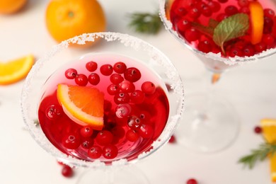 Tasty cranberry cocktail in glasses on white table, above view