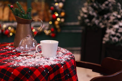 Photo of Served table in modern outdoor cafe. Christmas celebration