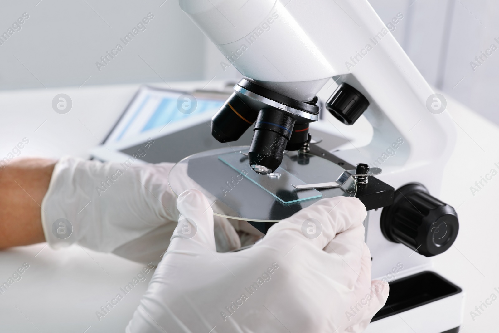 Photo of Doctor using microscope at table, closeup. Medical object