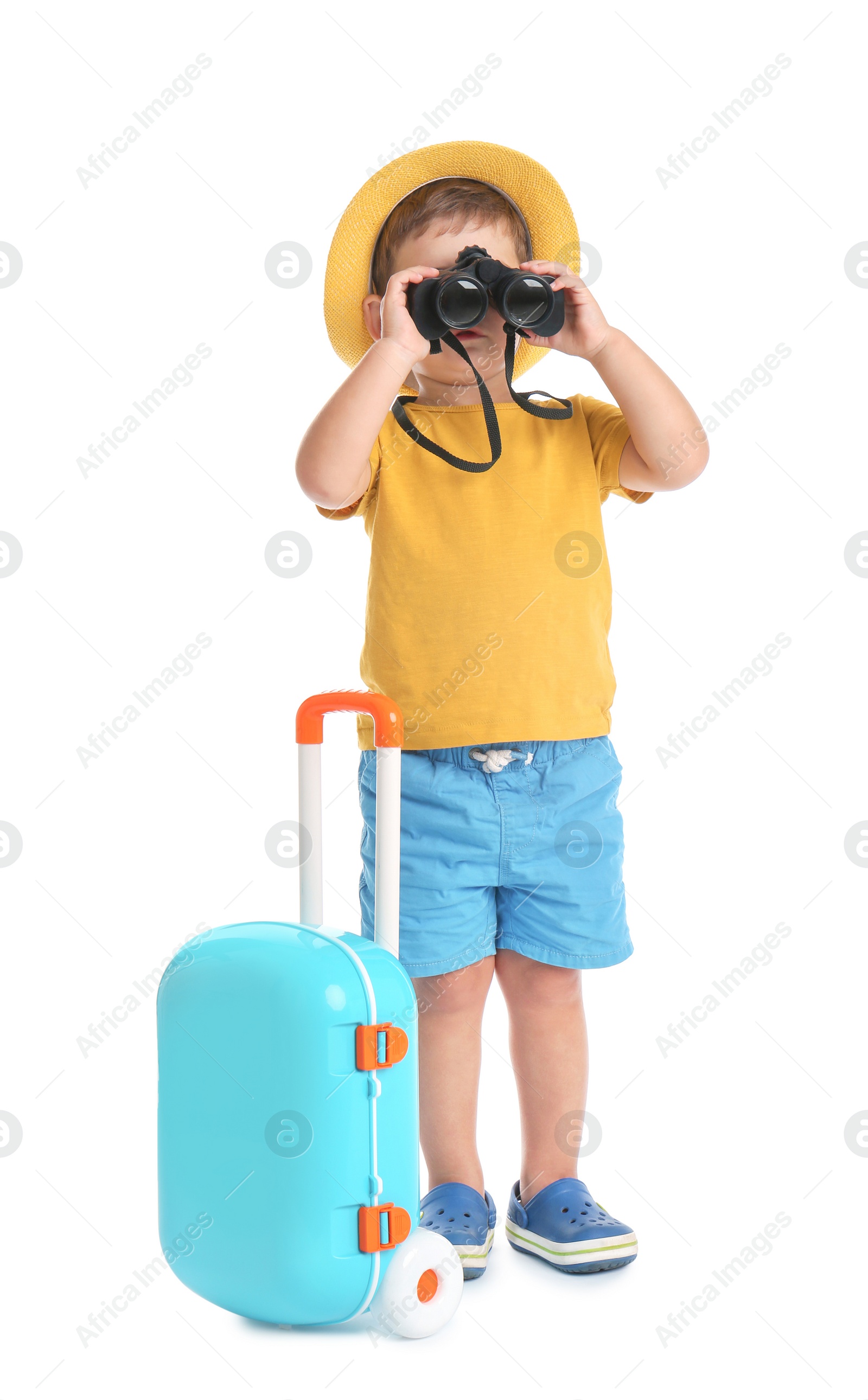 Photo of Cute little boy with hat, binocular and blue suitcase on white background