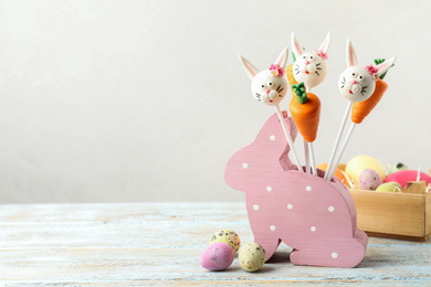 Photo of Delicious sweet cake pops on white wooden table, space for text. Easter holiday