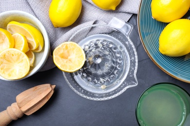 Photo of Flat lay composition with freshly squeezed lemon juice on dark table