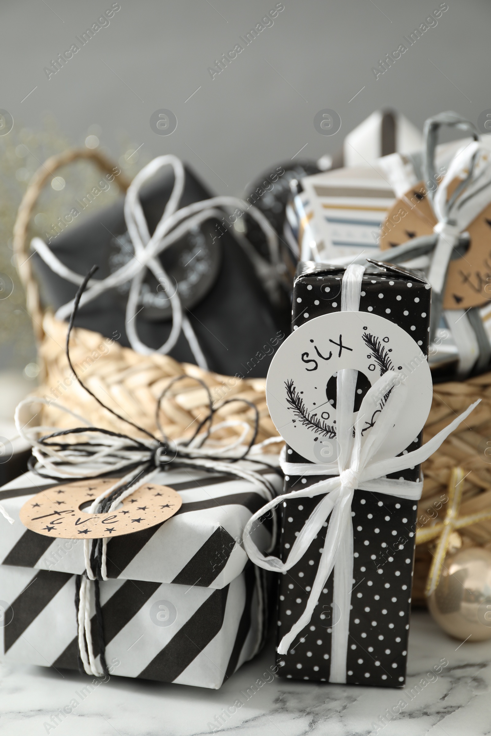 Photo of Gifts for Christmas advent calendar on white marble table, closeup