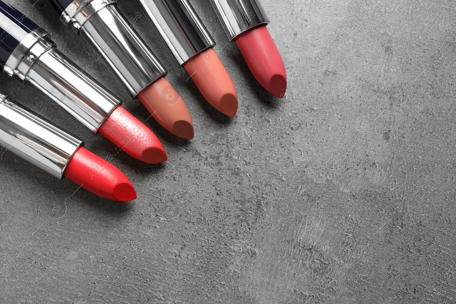 Photo of Different lipsticks and space for text on grey background, flat lay