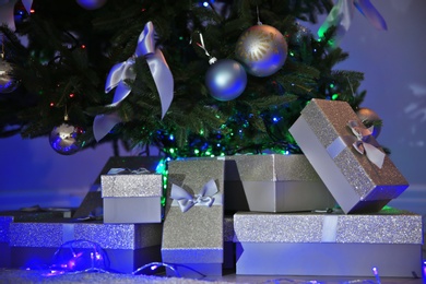 Beautiful Christmas tree with gift boxes indoors