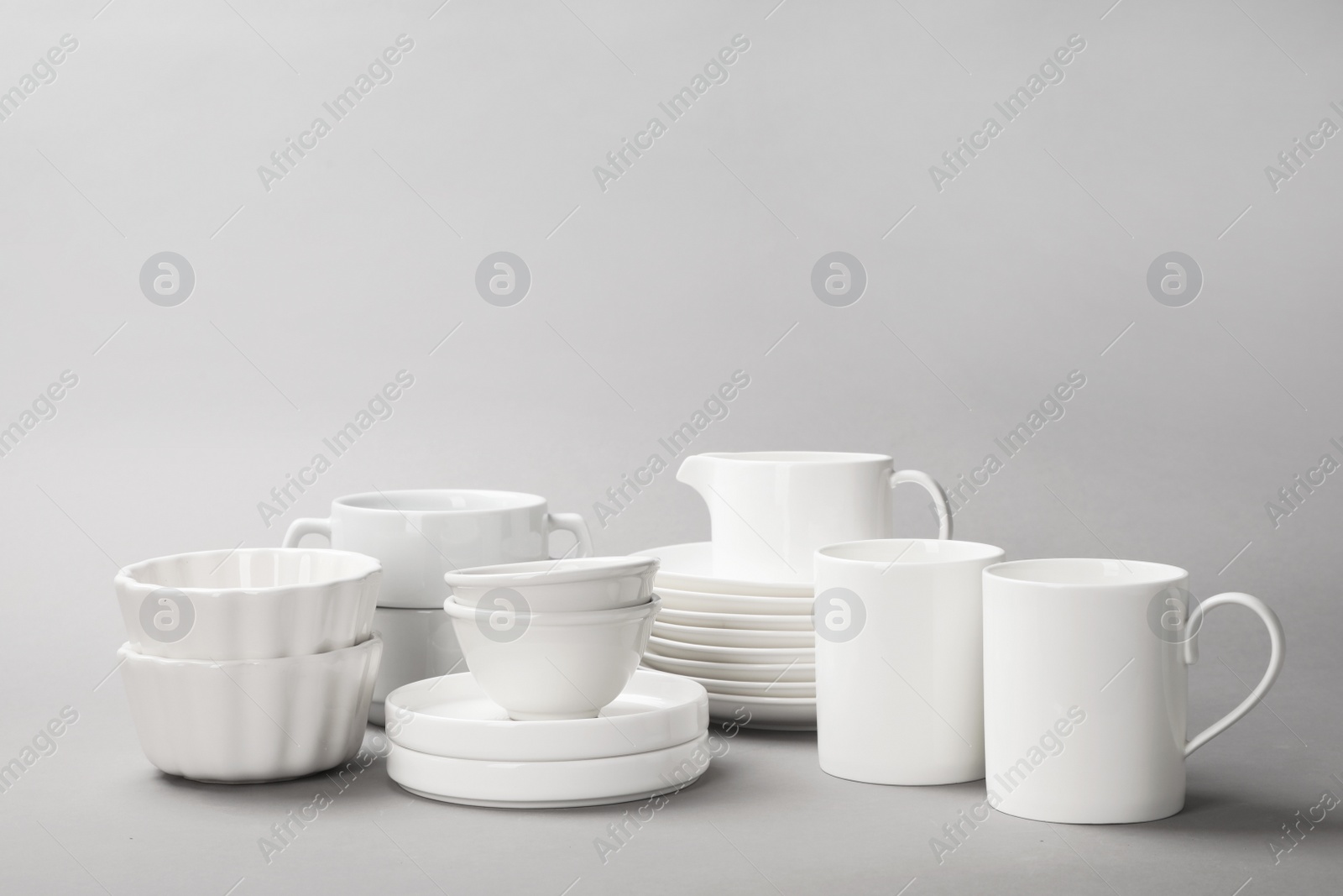 Photo of Set of clean tableware on grey background. Washing dishes