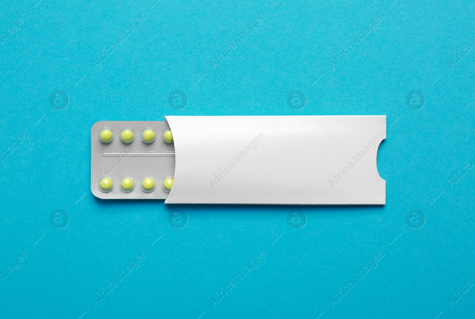 Photo of Birth control pills on light blue background, top view