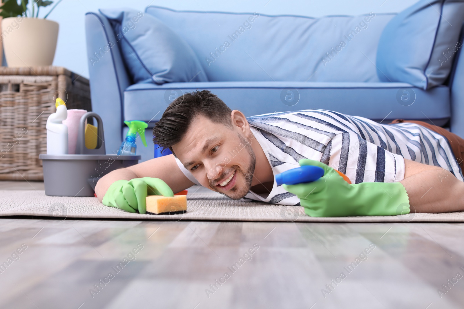 Photo of Mature man cleaning carpet at home