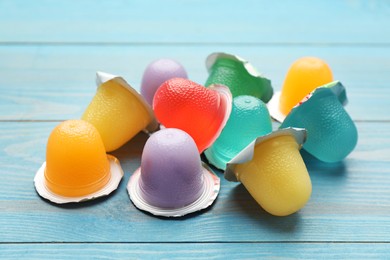 Photo of Tasty bright jelly cups on light blue wooden table