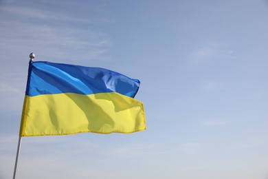 Photo of National flag of Ukraine against blue sky. Space for text