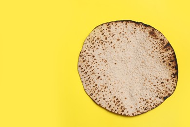 Photo of Tasty matzo on yellow background, top view with space for text. Passover (Pesach) celebration