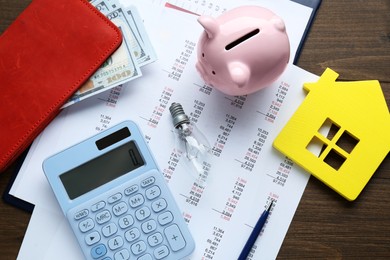 Photo of Flat lay composition with piggy bank and calculator on wooden table. Paying bills concept