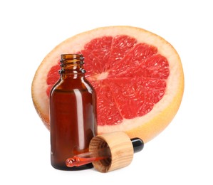 Photo of Bottle of citrus essential oil, pipette and fresh grapefruit on white background