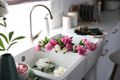 Photo of Bunch of beautiful peonies in kitchen sink