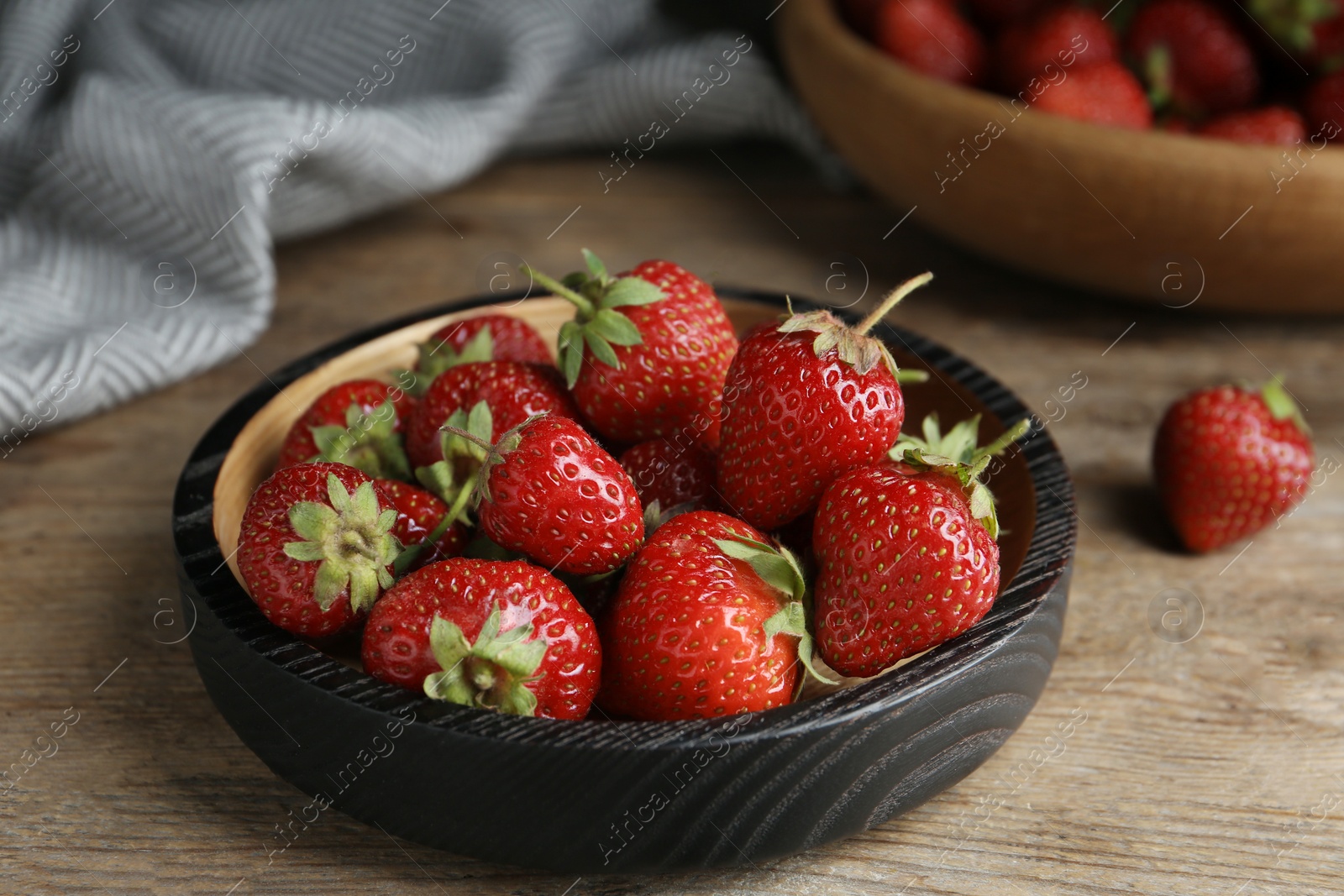 Photo of Delicious ripe strawberries on wooden plate, closeup