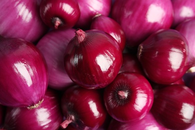 Pile of fresh red onions as background, closeup