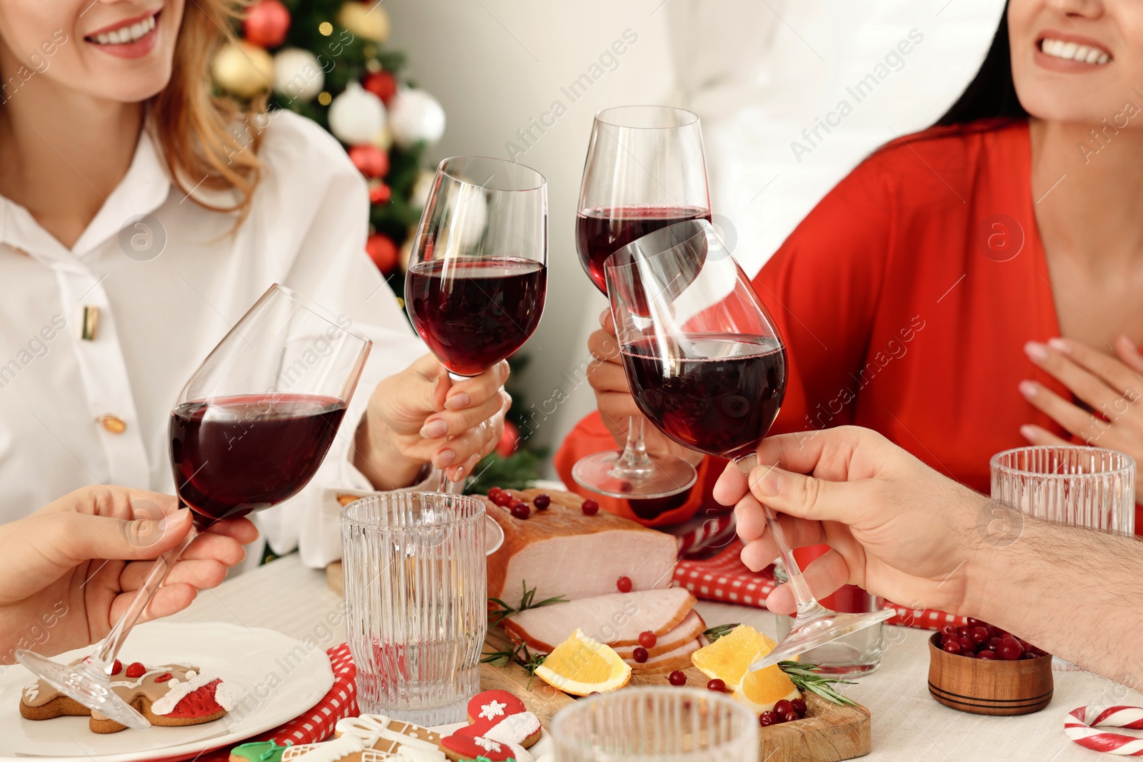 Photo of Family with their friends clinking glasses at festive dinner indoors, closeup. Christmas Eve celebration