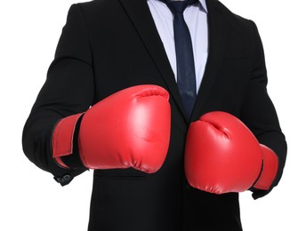 Businessman in suit wearing boxing gloves on white background, closeup