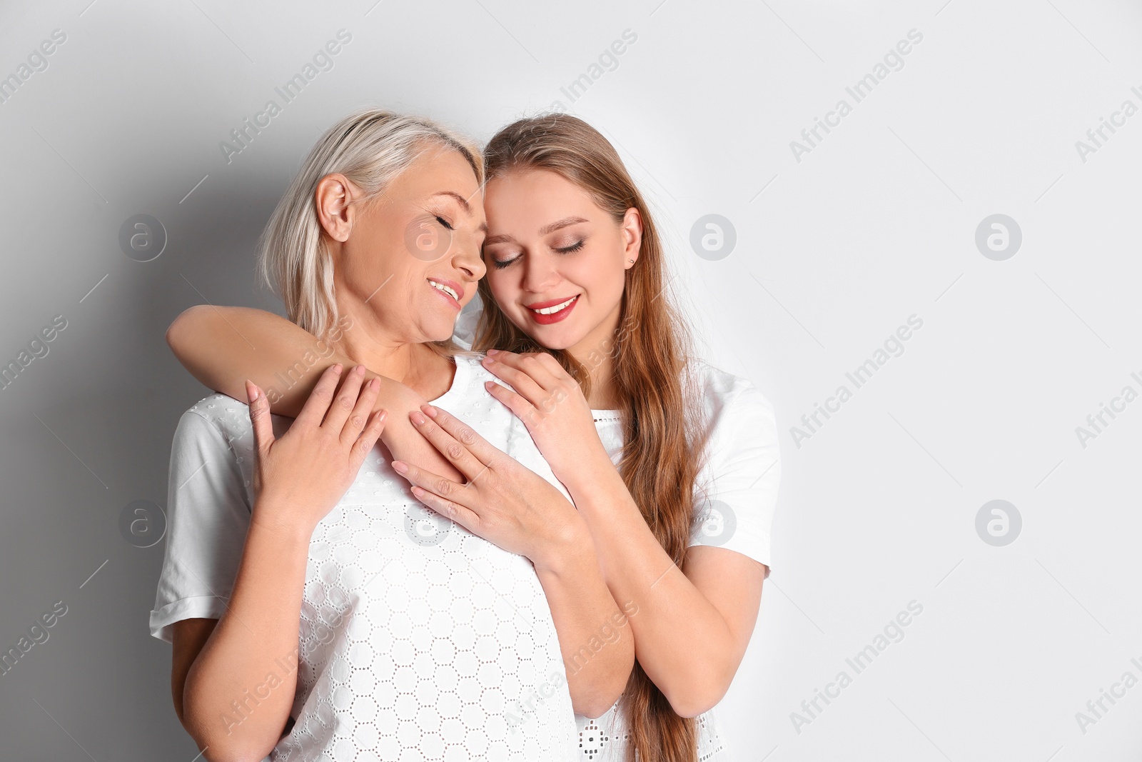 Photo of Mother and her adult daughter on white background