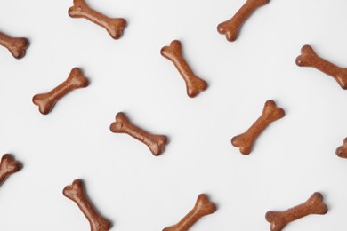 Flat lay composition with bone shaped dog cookies on white background