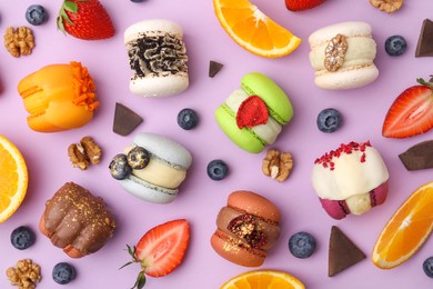 Delicious macarons, oranges and berries on violet table, flat lay