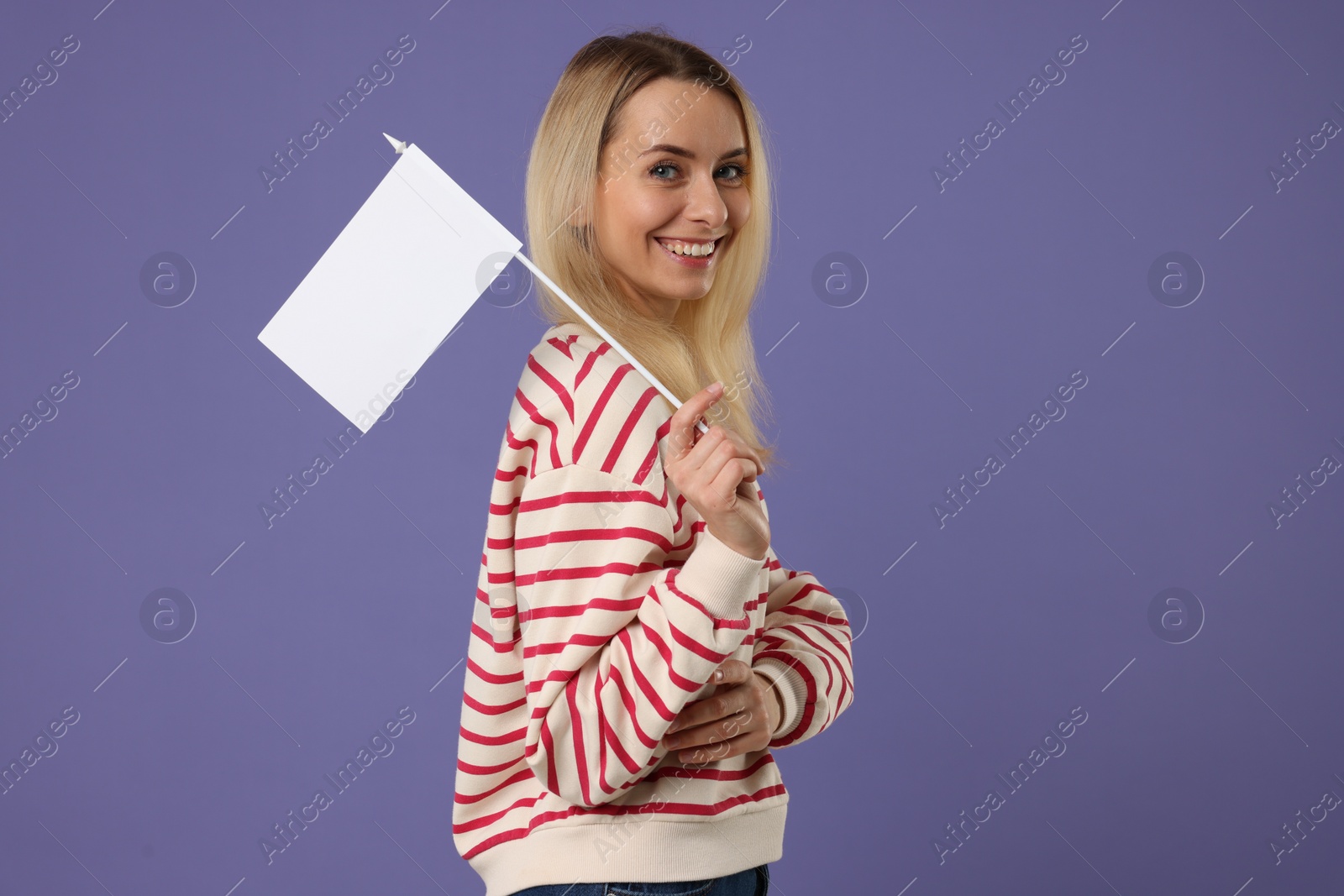 Photo of Happy woman with blank white flag on violet background. Mockup for design