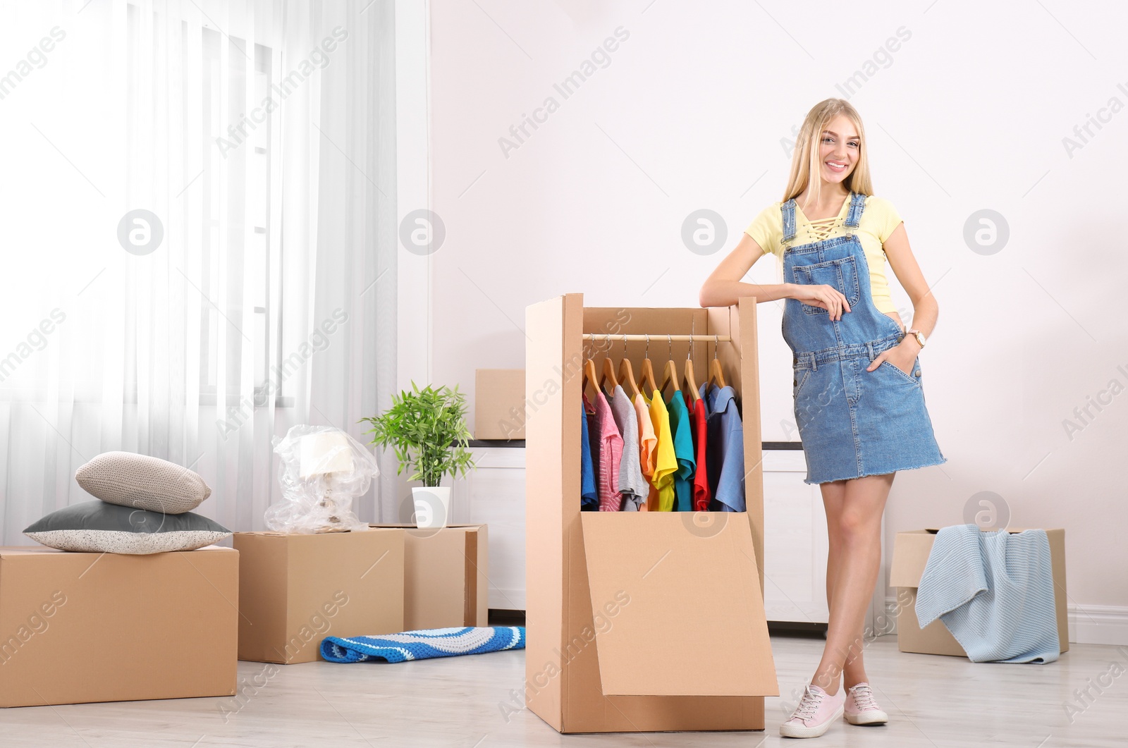 Photo of Young woman near wardrobe box at home