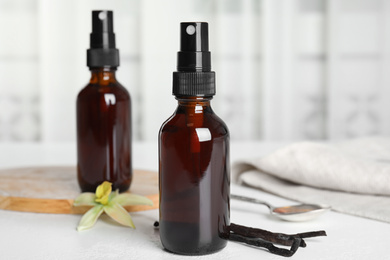 Photo of Aromatic homemade vanilla extract on white table